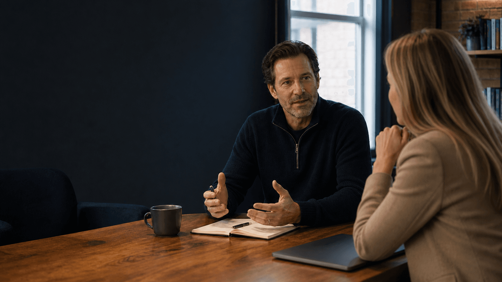 Executive coach speaking with a business owner at a conference table