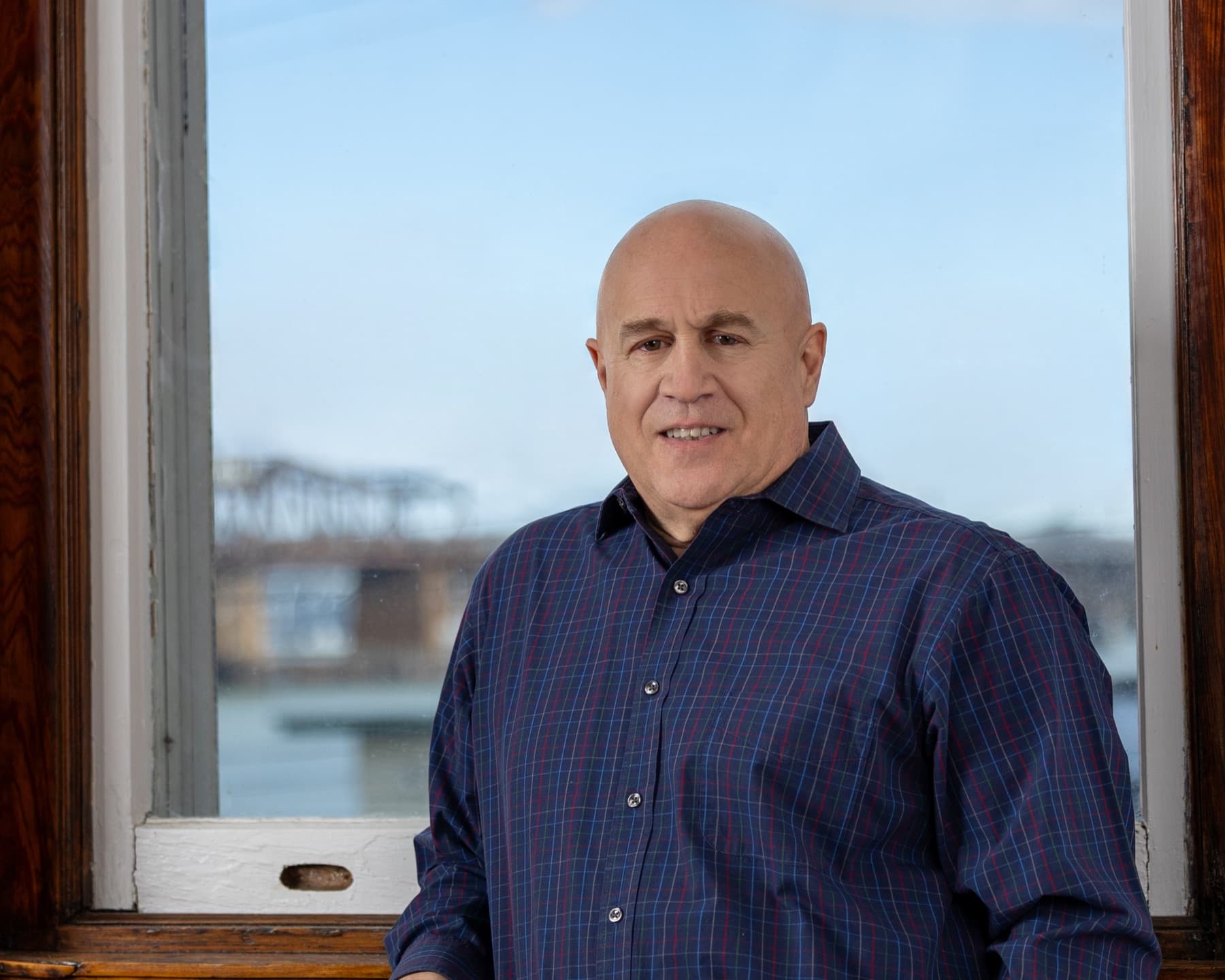 Paul beside a waterfront window